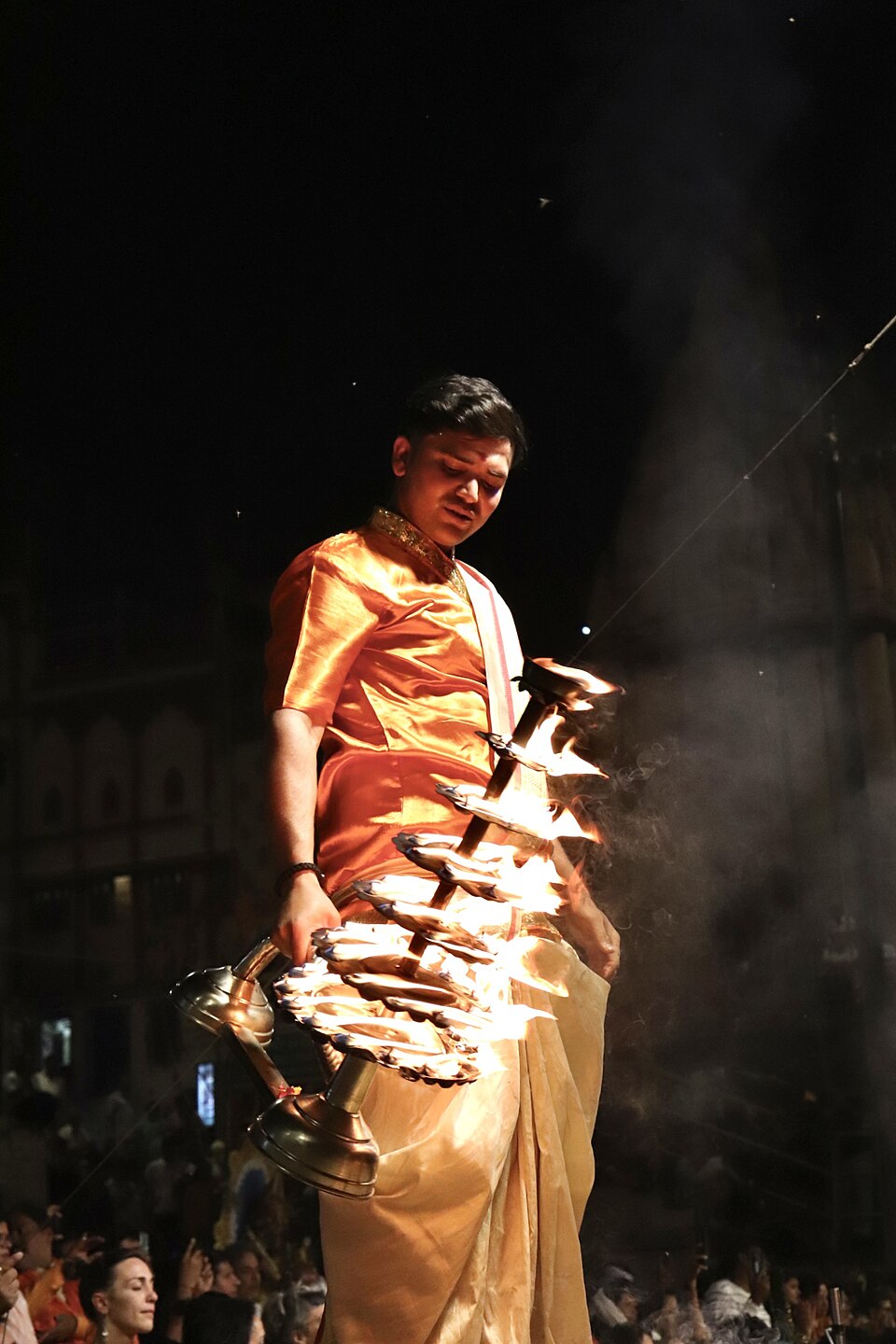 Priest holding a multi-wick aarti lamp